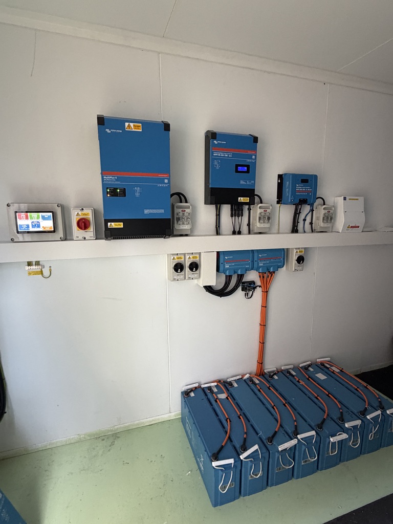 Victron MultiPlus-II, solar charge controllers, monitoring display and lithium battery bank inside the workshop