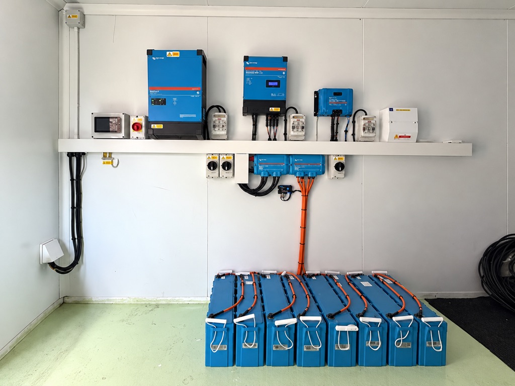 Victron inverter, solar charge controllers and battery bank in a detached garden workshop